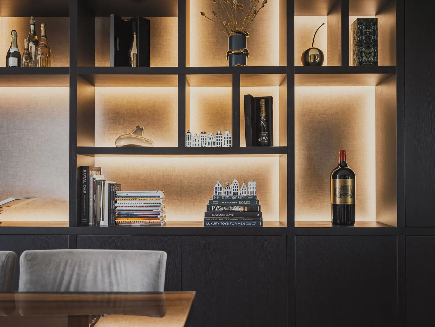 Detail van de verlichte vakken met boeken en bijzondere flessen