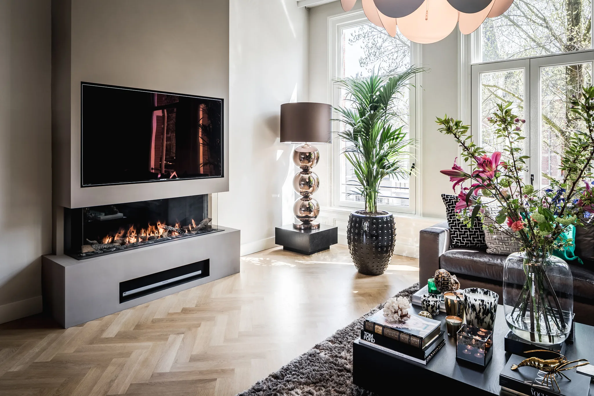 Woonkamer met gashaard en tv-wand, de koffietafel rechts op de voorgrond
