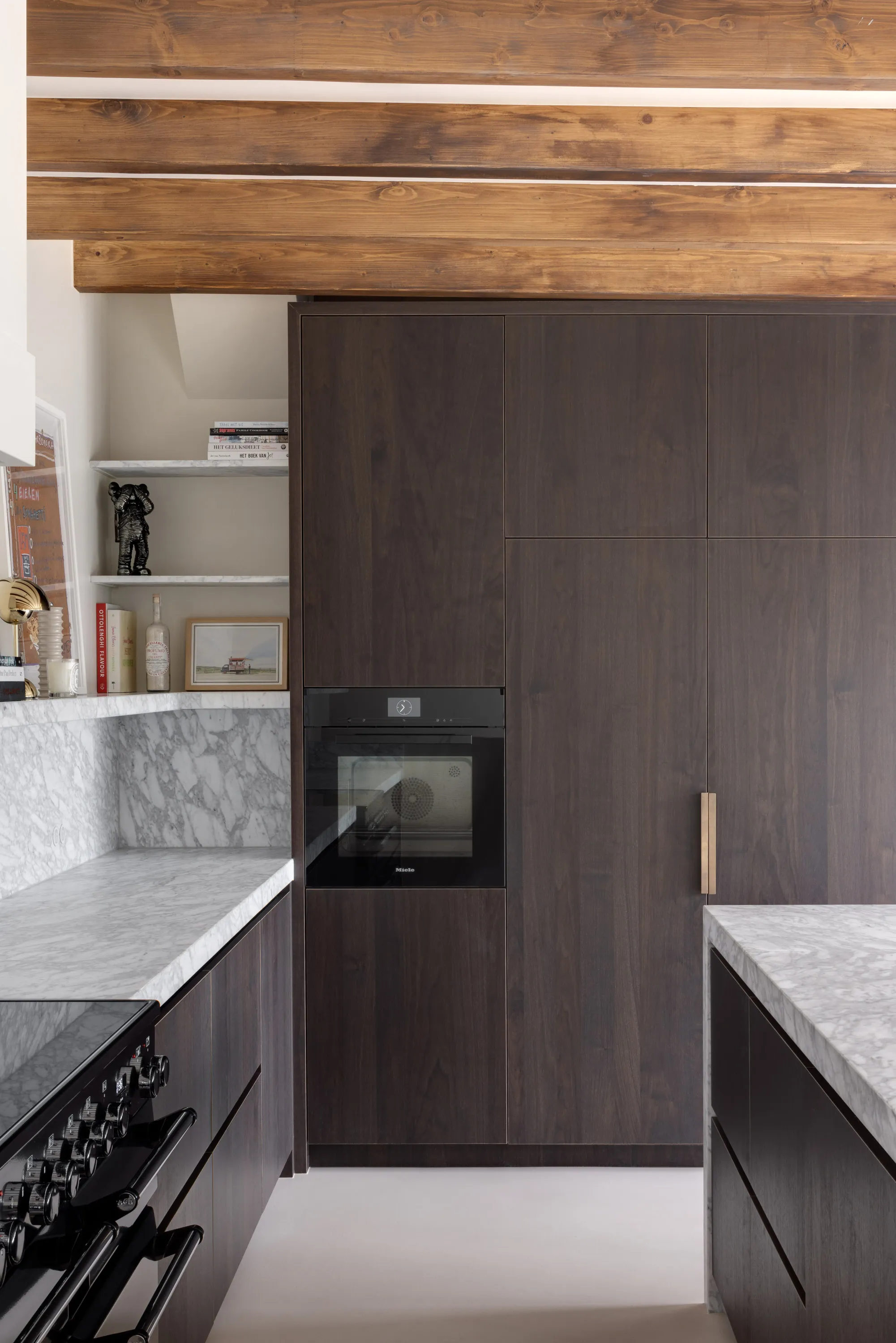 Ingebouwde Miele ovens in de donker gebeitste kastenwand