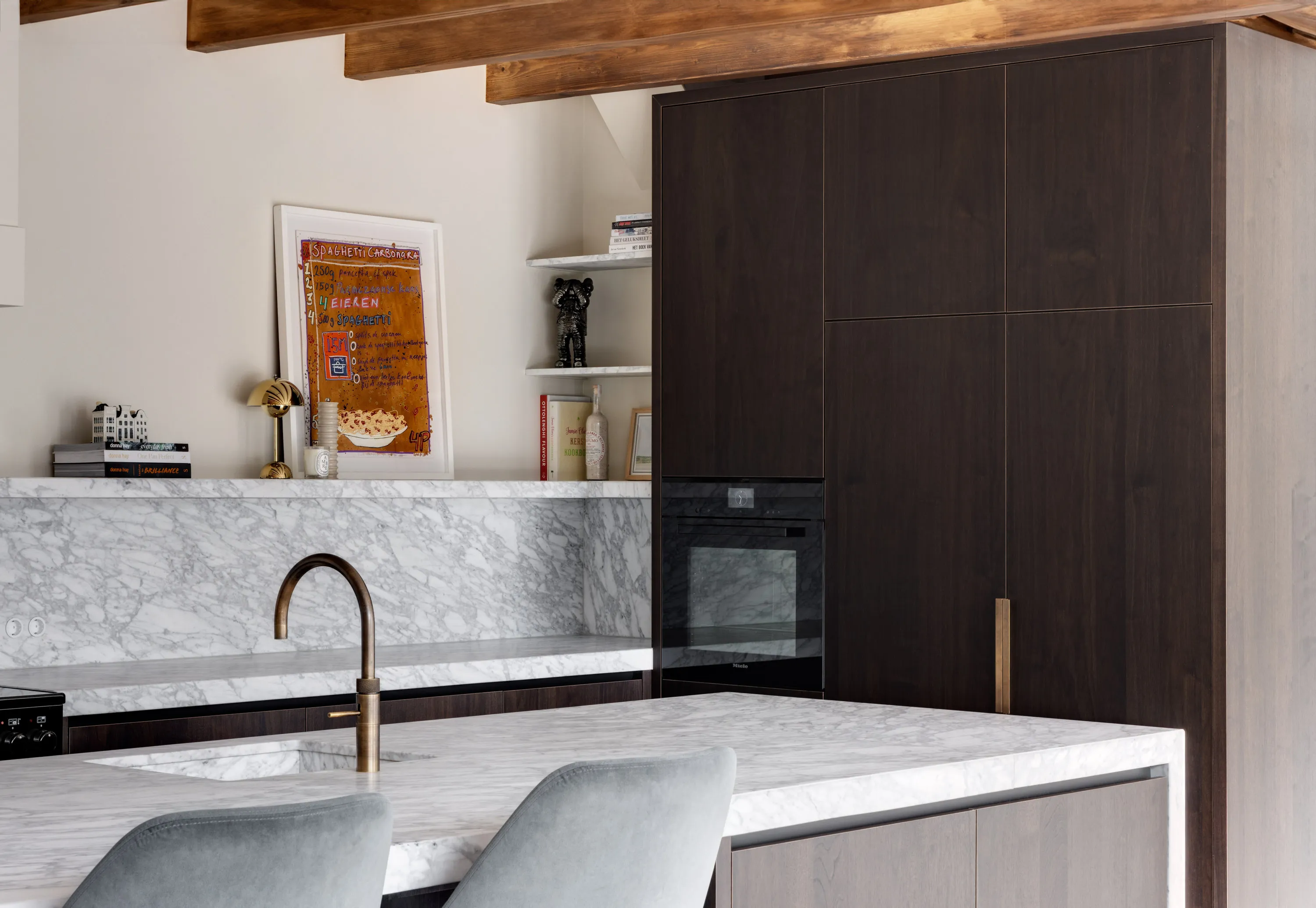Zwart gebeitste houten keuken met wit natuurstenen werkblad en eiland, gebouwd voor een woning in Laren