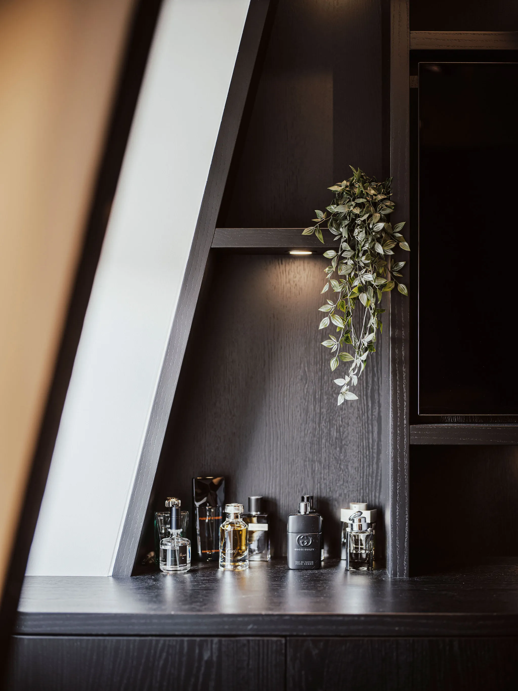 Detail van de aansluiting op de dakhelling met verlichte nis en parfumflessen