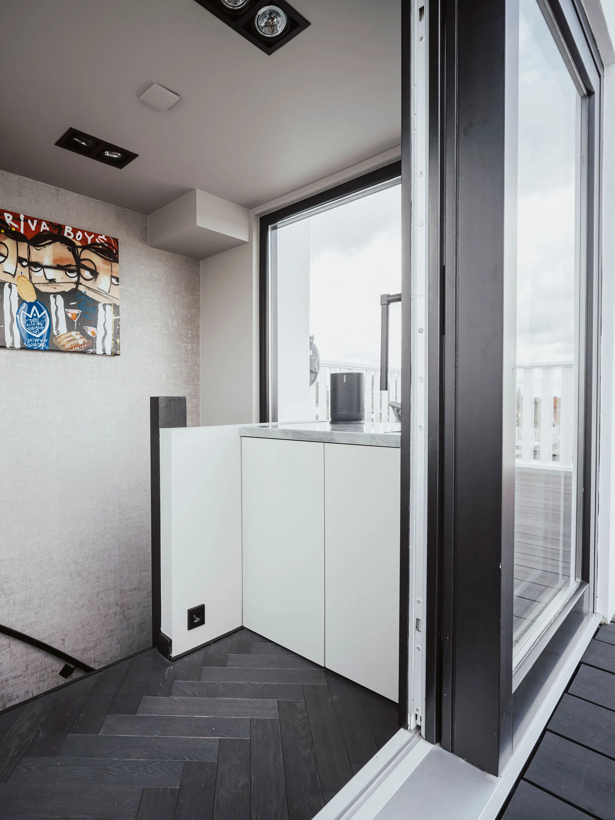 Compact wit keukentje met natuurstenen werkblad en greeploze fronten in het dakhuisje bij het dakterras